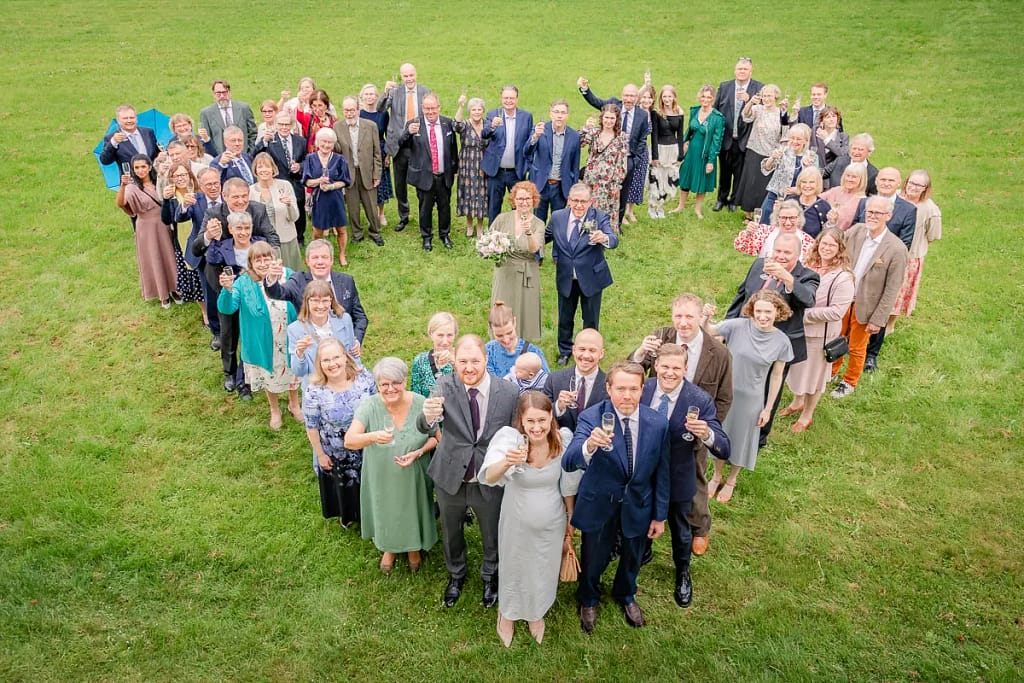 Gruppbild i form av ett hjärta på bröllop
