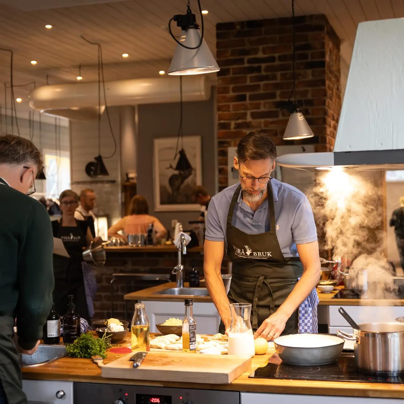 Bild på personer som lagar mat i Virå Bruks lokaler